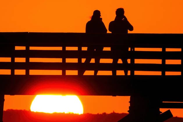 May 19, 2026, Isle Of Palms, Sc, United States: A couple takes photos from IOP Fishing Pier silhouetted by the sunrise over the Atlantic Ocean, May 19, 2026 in Isle of Palms, South Carolina. Isle Of Palms United States  - ZUMAe02_ 20260519_zaf_e02_009 Copyright: xRichardxEllisx