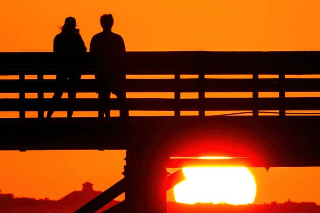 May 19, 2026, Isle Of Palms, Sc, United States: A couple takes photos from IOP Fishing Pier silhouetted by the sunrise over the Atlantic Ocean, May 19, 2026 in Isle of Palms, South Carolina. Isle Of Palms United States - ZUMAe02_ 20260519_zaf_e02_008 Copyright: xRichardxEllisx