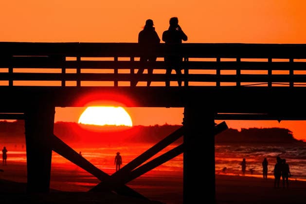 May 19, 2026, Isle Of Palms, Sc, United States: A couple takes photos from IOP Fishing Pier silhouetted by the sunrise over the Atlantic Ocean, May 19, 2026 in Isle of Palms, South Carolina. Isle Of Palms United States - ZUMAe02_ 20260519_zaf_e02_002 Copyright: xRichardxEllisx