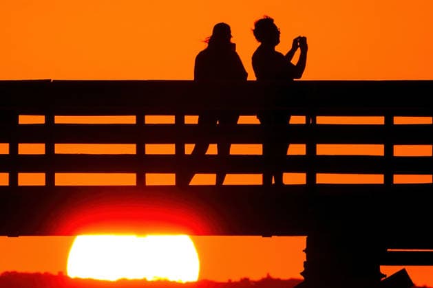 May 19, 2026, Isle Of Palms, Sc, United States: A couple takes photos from IOP Fishing Pier silhouetted by the sunrise over the Atlantic Ocean, May 19, 2026 in Isle of Palms, South Carolina. Isle Of Palms United States - ZUMAe02_ 20260519_zaf_e02_003 Copyright: xRichardxEllisx