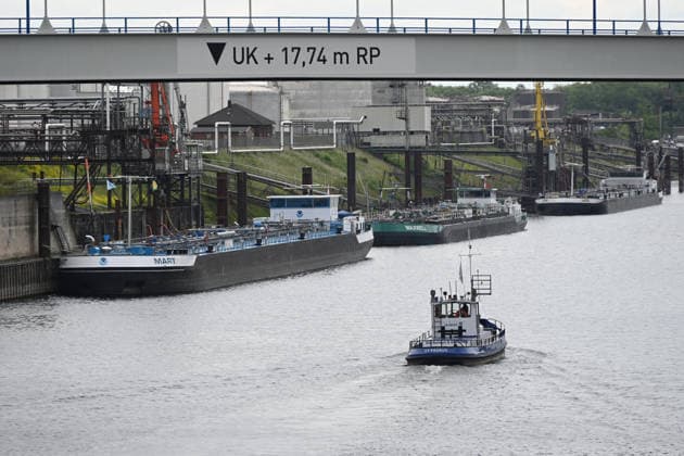 The boat Germanus of the port administration Duisport is sailing into the Duisburg oil port, in the background tankers are moored at the jetty, Duisburger Hafen, Duisport, on 19 05 2026 in Duisburg Germany