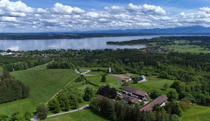 An early summer day near Tutzing, Starnberg district Here the view high above the Ilkahöhe to Oberzeismering, the Nikolauskircherl in the middle, Lake Starnberg and the Alps on the horizon, hiking, walking, cycling, view, local recreation, Munich area, weather picture, excursion weather