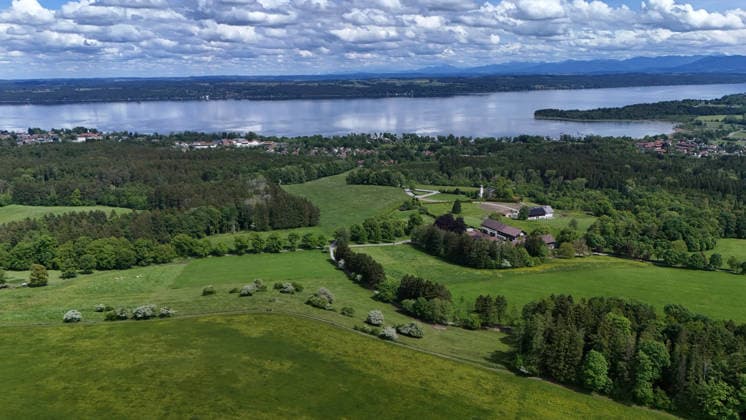 An early summer day near Tutzing, Starnberg district Here the view high above the Ilkahöhe to Oberzeismering, the Nikolauskircherl in the middle, Lake Starnberg and the Alps on the horizon, hiking, walking, cycling, view, local recreation, Munich area, weather picture, excursion weather