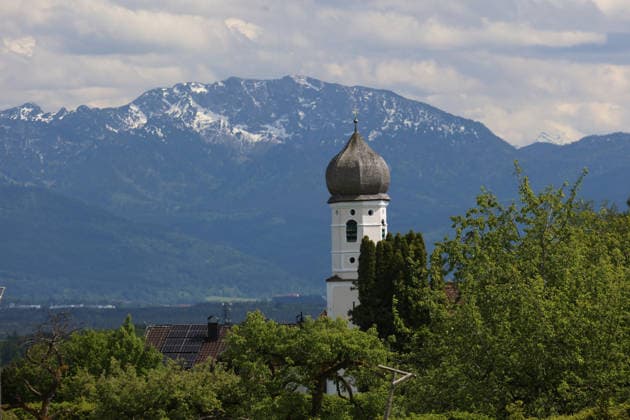 An early summers day near Tutzing, Starnberg district Here the view from the Ilkahöhe to the church tower of the Nikolauskircherl, with the Benediktenwand in the background