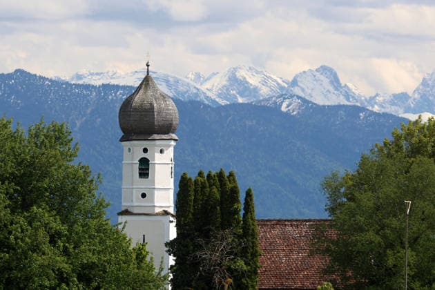 An early summers day near Tutzing, Starnberg district Here the view from the Ilkahöhe to the church tower of the Nikolauskircherl, with the Karwendel in the background