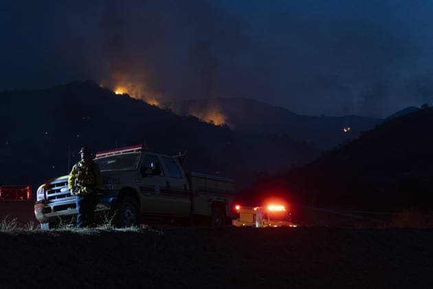 California wildfire burns over 1,300 acres, thousands evacuated SIMI VALLEY, CALIFORNIA, UNITED STATES - MAY 18: A firefighter stands beside a fire engine as flames burn through the mountains during the Sandy Fire in Simi Valley, California, United States, on May 18, 2026. A wildfire in the U.S. state of California has scorched more than 1,300 acres (nearly 526 hectares) of land, prompting the evacuation of thousands of people. The Sandy Fire broke out on Monday morning in the hills above Simi Valley, located roughly 30 miles (48 kilometers) northwest of Los Angeles, according to a statement released by California Governor Gavin Newsom’s Office. Myraneli Fabian Anadolu California United States. Editorial use only. Please get in touch for  Copyright: x2026xAnadoluxMyranelixFabianx