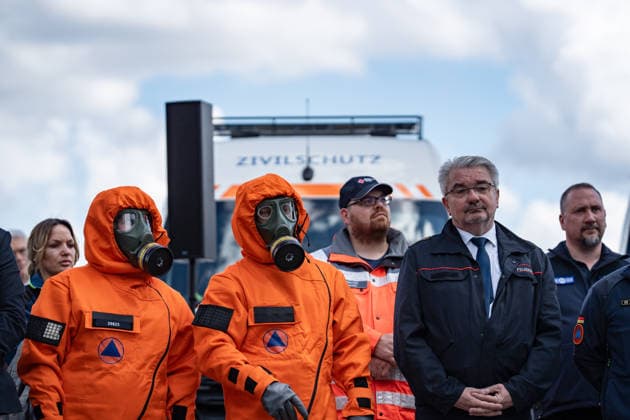Person with protective suit and breathing mask in front of a civil defense vehicle Presentation of the Civil Protection Pact by the Federal Minister of the Interior and the Minister of Defense with handover of 13 emergency vehicles to the civil defense, Berlin Berlin Germany Central Station, Washingtonplatz