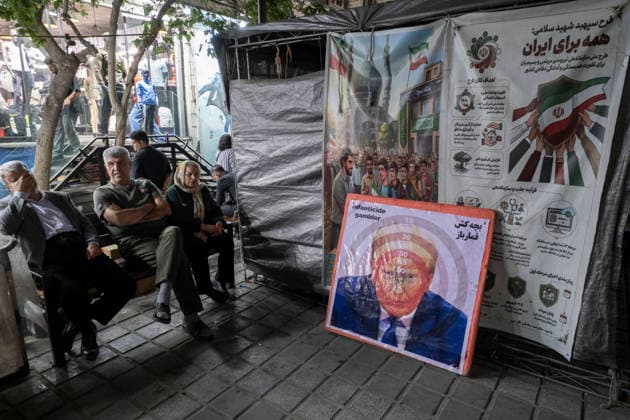 Daily Life In Iran Amid Threat About New Possible War People sit on a sidewalk next to a dartboard depicting a portrait of U.S. President Donald Trump in a business district in downtown Tehran, Iran, on May 22, 2026. U.S. President Donald Trump has indicated the possibility of military action against Iran if no agreement is reached with Iranian officials. Tehran Tehran Iran  Copyright: xMortezaxNikoubazlx originalFilename: nikoubazl-dailylif260522_npTac