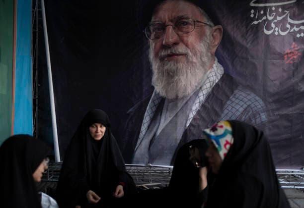 Daily Life In Iran Amid Threat About New Possible War A group of veiled Iranian women sit together beneath a banner depicting a portrait of Iran s late Supreme Leader Ayatollah Ali Khamenei in a business district in downtown Tehran, Iran, on May 22, 2026. U.S. President Donald Trump is reported to be considering military action against Iran if no agreement is reached with Iranian officials. Tehran Tehran Iran  Copyright: xMortezaxNikoubazlx originalFilename: nikoubazl-dailylif260522_npn2l