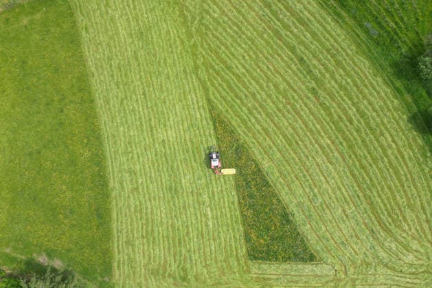 Aerial view spring spring in Siegerland A lush green meadow is mowed by a tractor with a mower mower near Siegen Oberschelden spring spring in Siegerland on 23 05 2026 in Siegen Germany