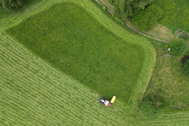 Aerial view spring spring in Siegerland A lush green meadow is mowed by a tractor with a mower mower near Siegen Oberschelden spring spring in Siegerland on 23 05 2026 in Siegen Germany