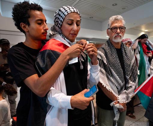 May 23, 2026, Montreal, Pq, CANADA: Safa Chebbi, left, and Ehab Lotayef, right, stand as Chebbi s son wraps her in a Palestinian flag as they arrive back at Montreal s Trudeau International Airport on Saturday, May 23, 2026. Chebbi and Lotayef were two of the 12 Canadians who were on board a flotilla trying to reach Gaza and spent four days in Israeli captivity. Montreal CANADA - ZUMAc35_ 20260523_zaf_c35_156 Copyright: xPeterxMccabex