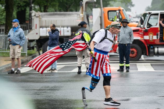 News Bilder des Tages May 25, 2026, Washington, District Of Columbia, Unites States: A Veteran runs with an American flag along the parade Route Washington Unites States  - ZUMAk206 20260525_znp_k206_007 Copyright: xMattxKaminskyx