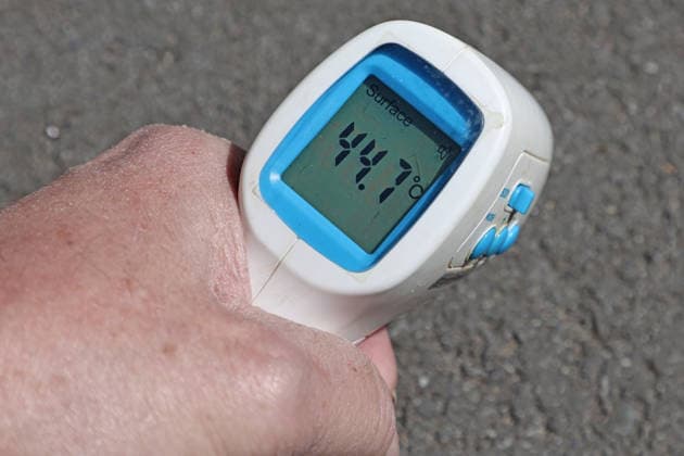 Summer heatwave A digital thermometer shows the temperature of the surface of an asphalt footpath
