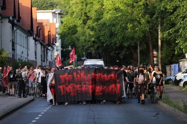 Protesters walk with banner Die Häuser denen sie brauchen in Templiner Straße during a demonstration against the eviction of the formerly squatted house Tornowstraße 40, Potsdam, May 26, 2026 Squatters demonstration in Potsdam