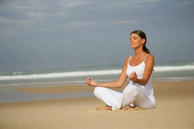 Portrait of a woman meditating by closing the eyes sitting at the seaside model released Symbolfoto Copyright: xphovoirx Panthermedia66642186.jpg