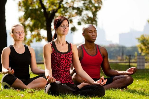 A group of people doing yoga in a city park model released Symbolfoto Copyright: xleafx Panthermedia68321332.jpg