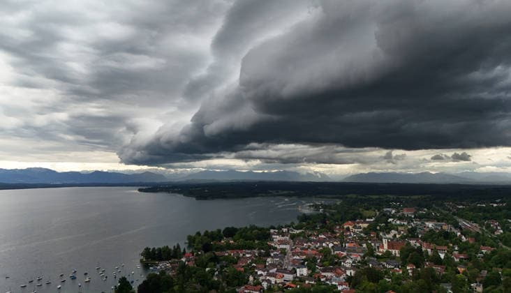 An early summer day in Tutzing, Starnberg district Here the view over the village and Lake Starnberg with the Alps on the horizon, where a thunderstorm is just coming up, a wall of clouds, thunderstorm roll, cloud roll, thunderstorm front, thunderstorm roll, thunderstorm front, dark clouds, weather picture