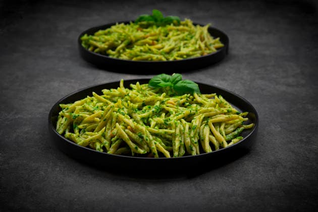 Trofie pasta with genovese pesto and basil on black plates, LVF09719
