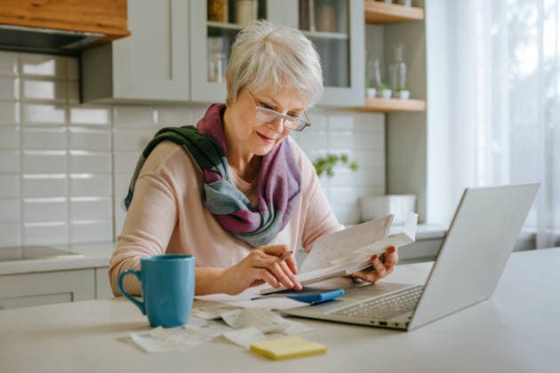 Woman calculating tax and budget with laptop in kitchen model released, Symbolfoto property released, YTF04873
