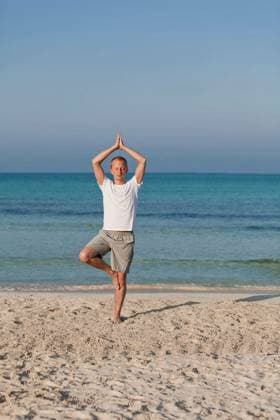 Young sporty man doing sport yoga on the beach in the sand by the sea in the sun model released Symbolfoto Copyright: xjuniartx Panthermedia68999544.jpg