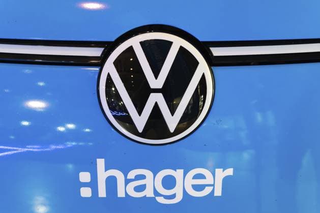 LISSABON, PORTUGAL — 16. MAI 2026: Symmetrische Nahaufnahme, die das Volkswagen Emblem zusammen mit einem weißen Hager Firmenaufkleber auf der Frontverkleidung eines blauen Elektroautos auf der ECAR Show zeigt LISBON, PORTUGAL - MAY 16, 2026: Symmetrical close-up showing the Volkswagen badge alongside a white Hager company sticker on a blue electric car front fascia at the ECAR Show exhibition Copyright: imageBROKER MaksimxZabarovskii iblmza18023231