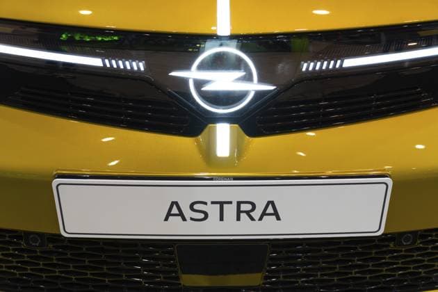 LISSABON, PORTUGAL — 16. MAI 2026: Symmetrische Nahaufnahme des leuchtenden Opel Blitz Emblems auf einer schwarzen Visor Verkleidung mit einem Astra Typenschild auf einem gelben elektrischen Schrägheck Auto auf der ECAR Show LISBON, PORTUGAL - MAY 16, 2026: Symmetrical close-up of the glowing Opel Blitz emblem on a black Vizor fascia with an Astra nameplate on a yellow electric hatchback car at the ECAR Show exhibition Copyright: imageBROKER MaksimxZabarovskii iblmza18023239