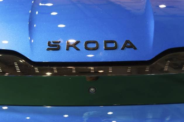 LISSABON, PORTUGAL — 16. MAI 2026: Symmetrische Nahaufnahme des dunkelverchromten Skoda Schriftzugs auf einer hellblauen Motorhaube über einem glänzenden schwarzen Tech Deck Face Panel auf der Elektrofahrzeugausstellung ECAR Show LISBON, PORTUGAL - MAY 16, 2026: Symmetrical close-up of the dark chrome Skoda lettering on a bright blue bonnet above a Tech-Deck Face glossy black panel at the ECAR Show electric vehicle exhibition Copyright: imageBROKER MaksimxZabarovskii iblmza18023244