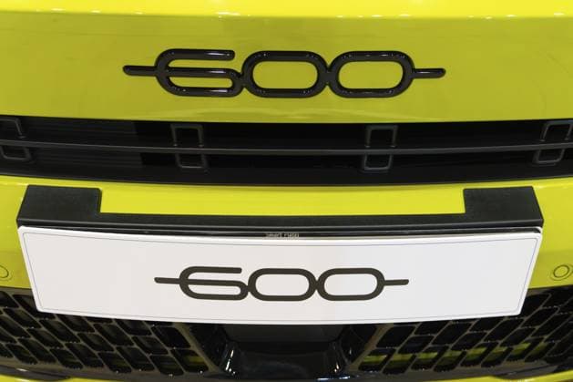 LISSABON, PORTUGAL — 16. MAI 2026: Symmetrische Nahaufnahme des schwarzen 600 Emblems mit Chromakzenten und dem passenden Modellschild auf einem leuchtend gelben Elektroauto Fiat 600e auf der ECAR Show LISBON, PORTUGAL - MAY 16, 2026: Symmetrical close-up of the black 600 chrome-accented emblem and matching model nameplate on a bright yellow Fiat 600e electric car at the ECAR Show exhibition Copyright: imageBROKER MaksimxZabarovskii iblmza18023250