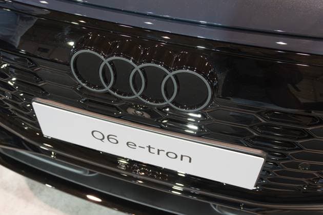 LISSABON, PORTUGAL — 16. MAI 2026: Symmetrische Nahaufnahme des zweidimensionalen Audi Ringlogos, des strukturierten schwarzen Kühlergrills und des Q6 e tron Typenschilds auf einem dunkelblauen Elektro SUV auf der ECAR Show LISBON, PORTUGAL - MAY 16, 2026: Symmetrical front close-up of the two-dimensional Audi rings logo, textured black grille, and Q6 e-tron nameplate on a dark blue electric SUV at the ECAR Show Copyright: imageBROKER MaksimxZabarovskii iblmza18023278