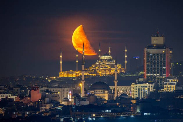 The moon rises over Taksim Mosque and Camlica Mosque, creating a striking view above the city skyline in Istanbul, Türkiye, Tuesday, June 9, 2026. (Melih Bagci - Depo Photos) Copyright: MelihxBagcix-xDepoxPhotos 19125888