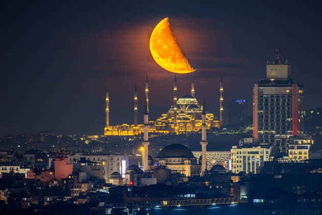 The moon rises over Taksim Mosque and Camlica Mosque, creating a striking view above the city skyline in Istanbul, Türkiye, Tuesday, June 9, 2026. (Melih Bagci - Depo Photos) Copyright: MelihxBagcix-xDepoxPhotos 19125889