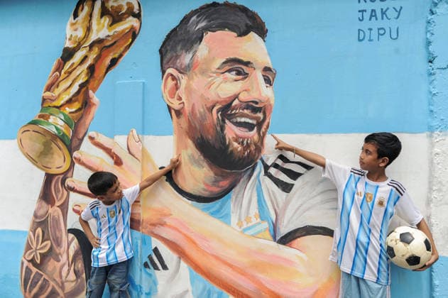 June 14, 2026: Sylhet, Bangladesh- Children wearing Argentina football jerseys gesture toward a mural of Argentine football player Lionel Messi in Sylhet, Bangladesh, on June 14, 2026. Football supporters in Bangladesh closely follow major international teams and players.  - ZUMAr143 20260614_zap_r143_002 Copyright: xMdxRafayatxHaquexKhanx