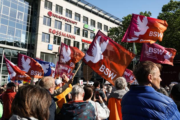 Participants in the rally with flags from the BSW BSW rally in Magdeburg Saxony-Anhalt on Willy Brandt Platz at the main railway station under the motto, World Cup 2026 Away with Merz
