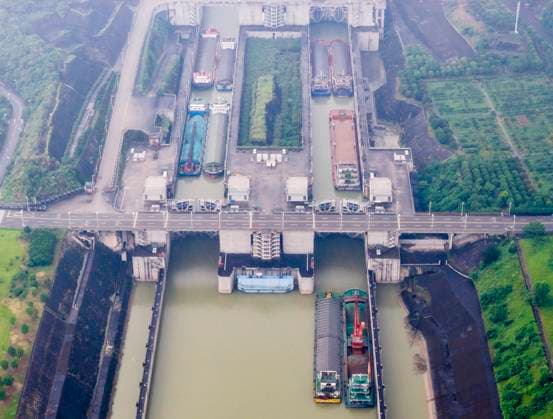 (260618) -- YICHANG, June 18, 2026 -- An aerial drone photo taken on June 18, 2026 shows ships passing through the dual-channel five-tier ship locks of the Three Gorges Dam in Yichang, central China s Hubei Province. Thursday marks the 23rd anniversary of the operation of the ship locks of the Three Gorges Dam, the world s largest hydropower project. Over the past 23 years, the ship locks have handled over 1.11 million vessels, and facilitated a total freight volume of 2.4 billion tonnes, according the China Three Gorges Corporation. (Photo by Xinhua) CHINA-HUBEI-YICHANG-THREE GORGES DAM-23 YEARS-CARGO THROUGHPUT (CN) ZhengxJiayu
