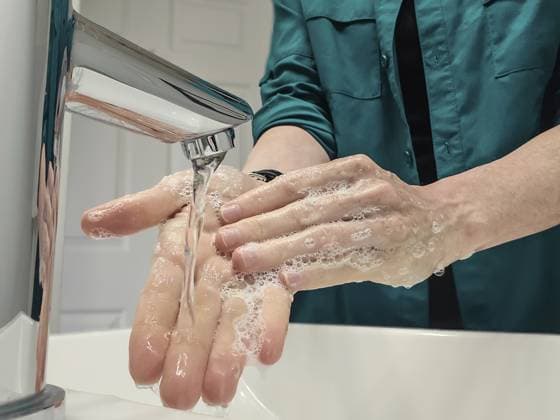 Nahaufnahme einer Frau in Freizeitkleidung, die sich unter einem Waschbeckenhahn bei hellem Licht die Hände mit Seifenwasser wäscht Closeup of a woman in casual clothing washing hands with soapy water under a sink faucet with bright lighting Copyright: imageBROKER mailcaroline ibxbpb17607074.jpg