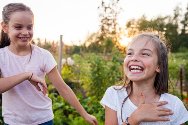 Two young sisters laughing together outdoors at sunset Langley, British Columbia, Canada CR_JDIP260630-2071821-01 ,model released, Symbolfoto