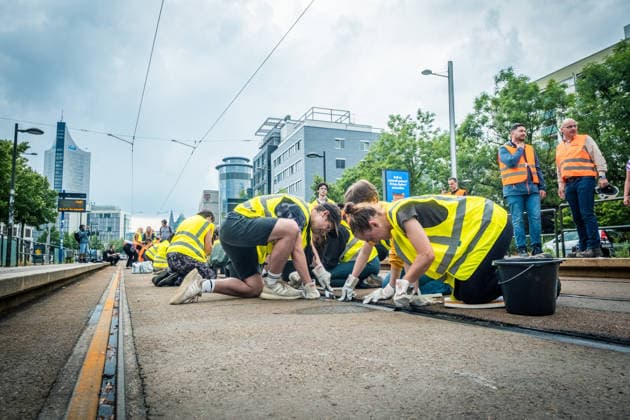 Residents of Leipzig are working together with the Leipzig Public Transportation Authority (LVB) to clear melted asphalt from the tram tracks at Johannisplatz. After about 100 volunteers had already responded to a call for help from the LVB the previous day, cleanup efforts continued on t