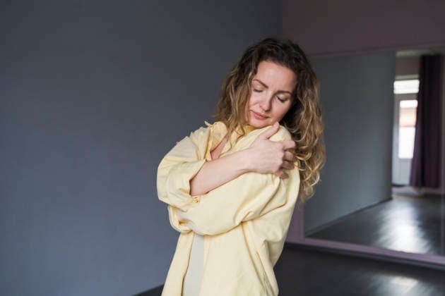 Yogini in yellow shirt hugging body indoors for self care model released, Symbolfoto, OSF02770