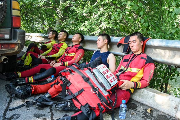 (260711) -- NANNING, July 11, 2026 -- Rescuers take turns to rest by a street in Guigang, south China s Guangxi Zhuang Autonomous Region, July 10, 2026. Triggered by Typhoon Maysak, the tenth typhoon of the year, heavy downpours battered multiple areas in south China s Guangxi Zhuang Autonomous Region, resulting in a series of disasters. Various response forces have pooled their efforts, carrying out operations including rescue missions in remote mountainous areas, restoration of transport and power infrastructure, and silt clearing operations. ) CHINA-GUANGXI-TYPHOON-FLOOD-RESCUE (CN) CaoxYiming