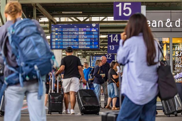 Travelers at the train station, passengers, and a departure board at Stuttgart Central Station, July 21, 2026, Stuttgart, Baden-Württemberg, Germany