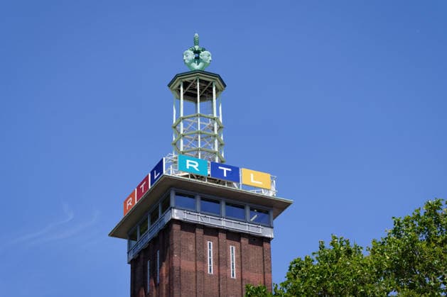 Detailed view of Trade fair towers in Cologne with the colourful RTL Channel logo and the distinctive Top of the tower before blue Summer sky with Greens Browse 1133503098