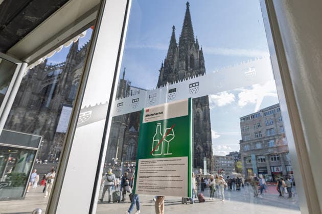 Alcohol Ban at Cologne Central Station: A Deutsche Bahn sign regarding the alcohol ban at Cologne Central Station, with Cologne Cathedral in the background. In response to increasing violence against rail staff and passengers, as well as a recent assault on a security officer, DB InfraGO is expanding the alcohol ban—which has been in effect i Copyright: xMarcxJohnx