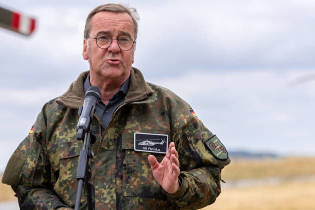 Federal Minister Boris Pistorius Visits Transport Helicopter Regiment 30, Külsheim, July 23, 2026 Federal Minister of Defense Boris Pistorius speaks into a microphone, wearing a Flecktarn uniform with a name tag reading BM Pistorius. He gestures with his right hand and appears to be expl 20260723-1V9A5956-M4000