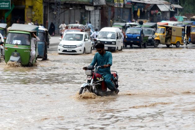 July 31, 2026, Peshawar, Peshawar, Pakistan: Residents wade through flooded street as monsoon rains inundate Peshawar..People wade through a flooded street during heavy monsoon rain in Peshawar, Khyber Pakhtunkhwa province, Pakistan, on July 31, 2026. Pakistan s Meteorological Department (PMD) forecast the current monsoon spell to continue until August 5, warning of widespread rain, thunderstorms, heavy to very heavy downpours, and the risk of urban flooding, flash floods, landslides and river flooding across parts of the country. Peshawar Pakistan - ZUMAa217 20260731_znp_a217_007 Copyright: xHussainxAlix