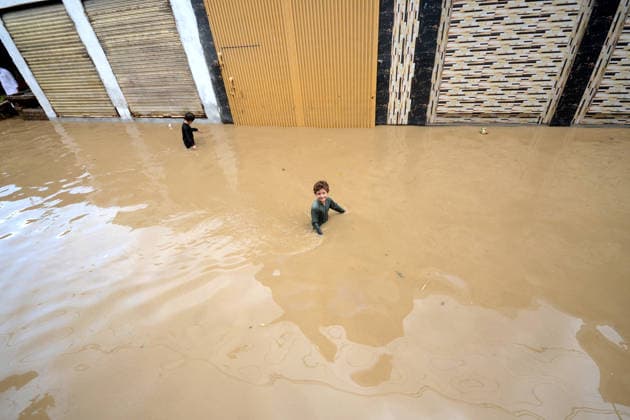 July 31, 2026, Peshawar, Peshawar, Pakistan: Residents wade through flooded street as monsoon rains inundate Peshawar..People wade through a flooded street during heavy monsoon rain in Peshawar, Khyber Pakhtunkhwa province, Pakistan, on July 31, 2026. Pakistan s Meteorological Department (PMD) forecast the current monsoon spell to continue until August 5, warning of widespread rain, thunderstorms, heavy to very heavy downpours, and the risk of urban flooding, flash floods, landslides and river flooding across parts of the country. Peshawar Pakistan - ZUMAa217 20260731_znp_a217_023 Copyright: xHussainxAlix