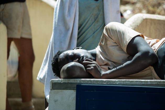 August 1, 2026, Ceuta, Spain: A man sleeps on a bench outside the The Ceuta Temporary Immigrant Stay Center (CETI). CETI is currently facing extreme tension and severe overcrowding, reaching a state of absolute collapse. The facility has been forced to close its doors to new male arrivals due to a critical lack of space. Ceuta Spain - ZUMAd308 20260801_zsp_d308_048 Copyright: xJuanxCarlosxLucasx