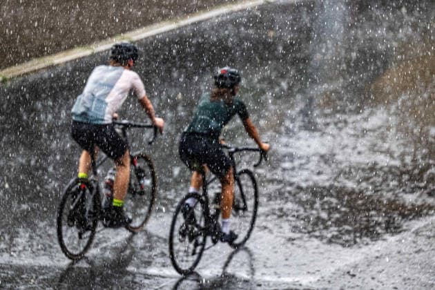 Heavy Rain in Göttingen, August 3, 2026; Göttingen: Two cyclists ride through Göttingen during a heavy rainstorm; Göttingen, Lower Saxony, Germany