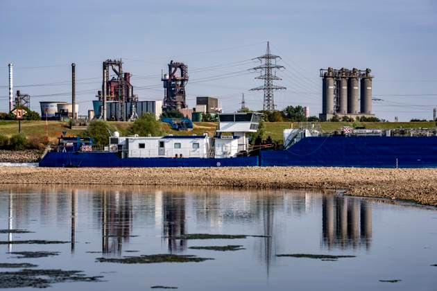 Extremely low water levels—here at the Thyssenkrupp Steel plant in Duisburg-Marxloh—have caused sandbars to form due to the low water level in the Rhine; cargo ships can only sail with reduced cargo; the TKS steel mill has cut back production because not enough raw