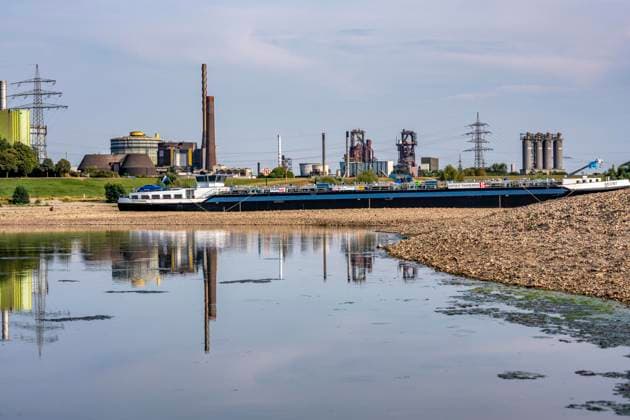 Extremely low water levels—here at the Thyssenkrupp Steel plant in Duisburg-Marxloh—have caused sandbars to form due to the low water level in the Rhine; cargo ships can only sail with reduced cargo; the TKS steel mill has cut back production because not enough raw